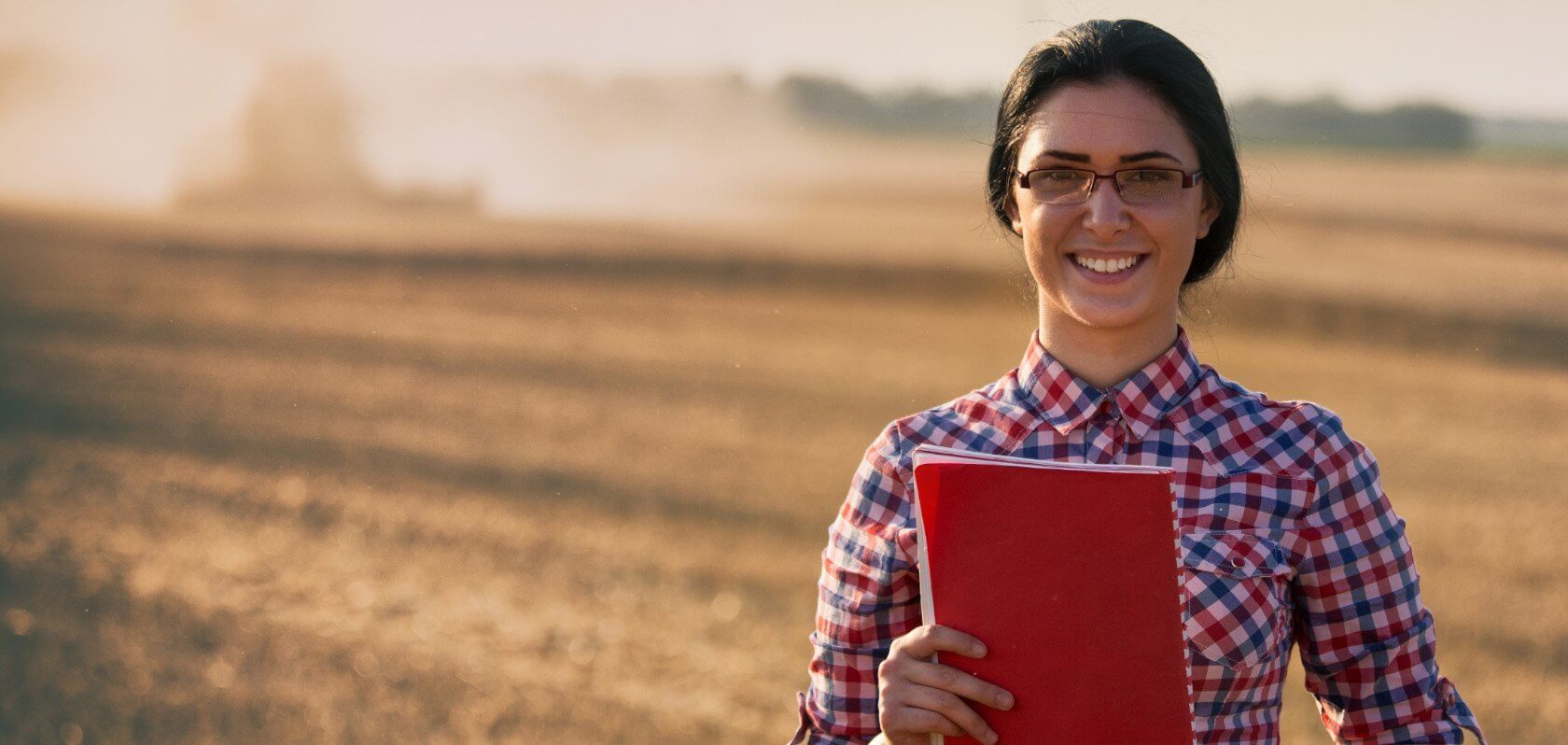Woman in a rural scene holding a folder